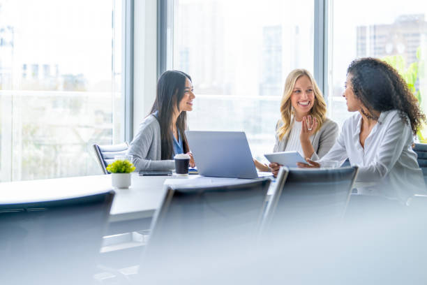 istock Three business  women meeting. They are discussing something while looking at a laptop computer. 2200685343
