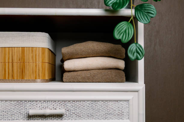 istock Three stylish wool sweaters on a shelf in the closet. 2200689443