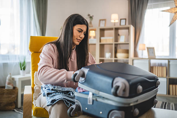 istock One woman pack suitcase baggage prepare for vacation holiday 2200691659