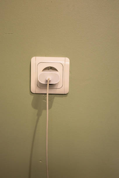 istock Electrical Outlet with Plug and Charger on Green Wall 2200698731