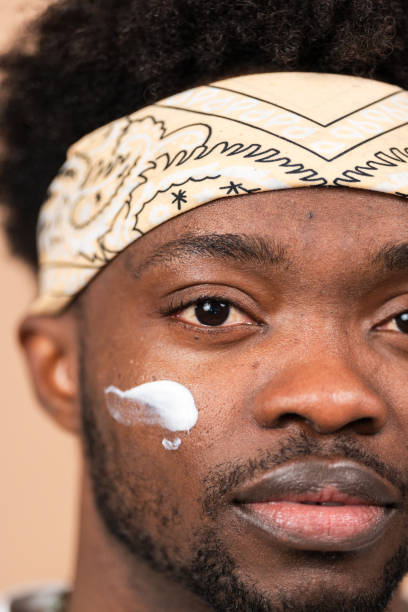 istock man applying moisturizing cream on face for skincare 2200700058