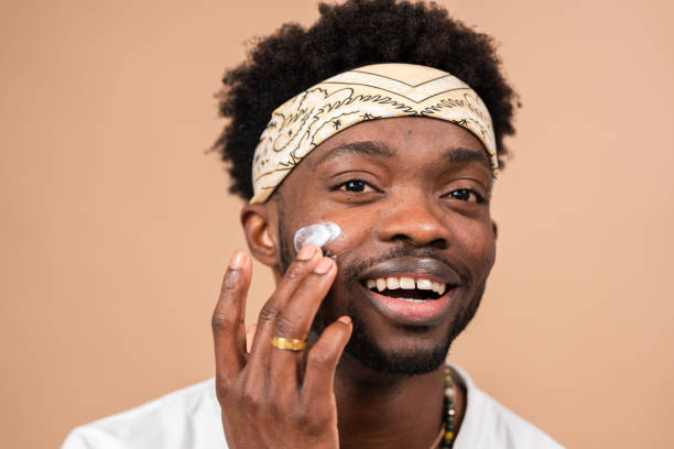 istock man applying cream on face for skincare routine 2200700524