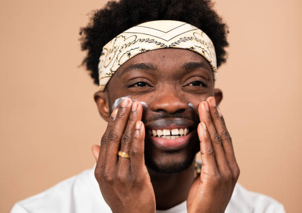 istock man applying cream on face for skincare routine 2200702973