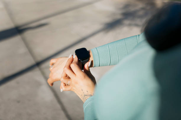 Female athlete monitoring her performance on a smartwatch during an outdoor workout