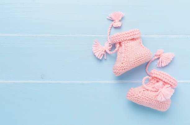 istock Pink baby booties on wooden background, top view 2200706833