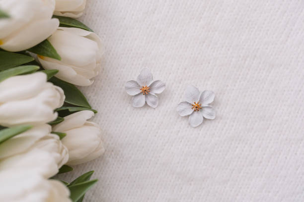 istock Delicate white flowers beside fresh tulips on a light background 2200713267
