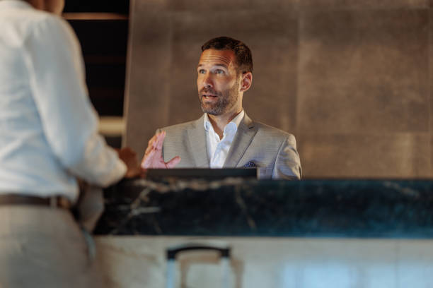 istock Hotel receptionist assisting businessman at the front desk 2200713356
