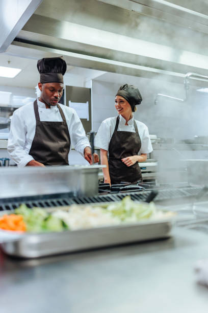 istock Two chefs cooking vegetables in a professional kitchen 2200713414