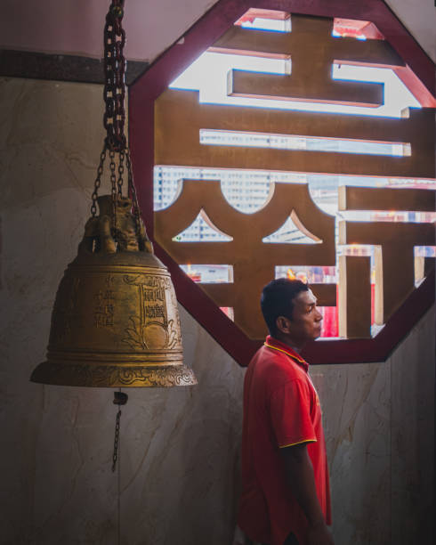 Balikpapan, Indonesia - January 29th, 2025. The temple worker will usually ring the bell when visitors enter the temple to pray.