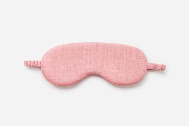istock Sleeping mask for healthy quality sleep on white light background. One pink colored eye mask for best sleeps. Stylish silk eye cover or blindfold for travel, comfort rest, minimal top view 2200719993
