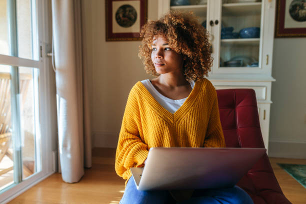 istock Woman working from home using laptop and looking away pensively 2200720621