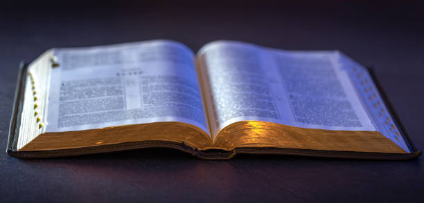 istock Open Holy Bible on the table. Religion concept. Bible on black background. 2200730490