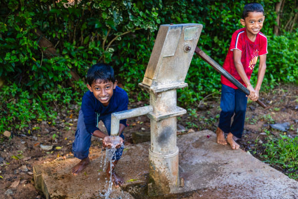Sri Lankan young boys drinking a fresh water, Sigiriya, Ceylon.