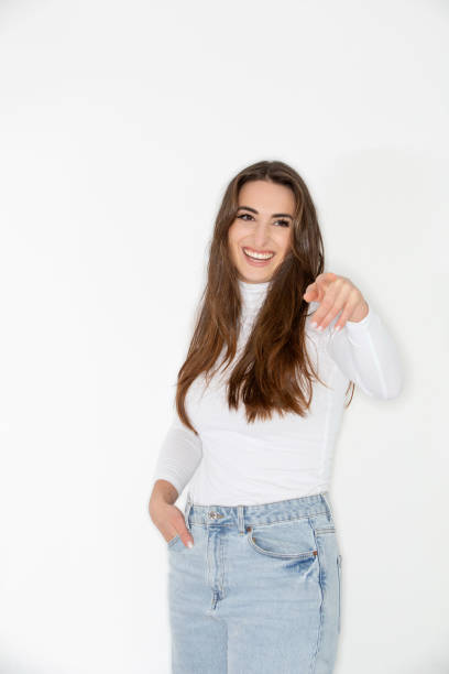 istock Beautiful young woman pointing and smiling 2200735367