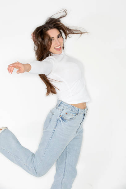 istock Playful Beautiful young woman jumping against white background 2200735384