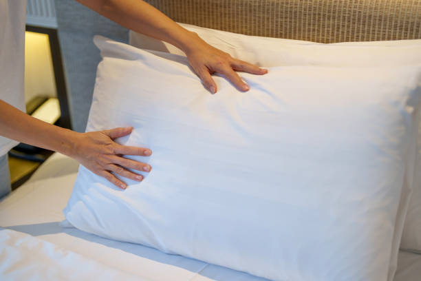 istock Hotel Staff Adjusting Fresh White Pillow on Bed 2200735690