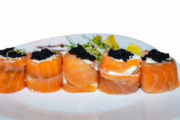 istock Rolls of sushi from red fish with black caviar on a white plate 2200743786