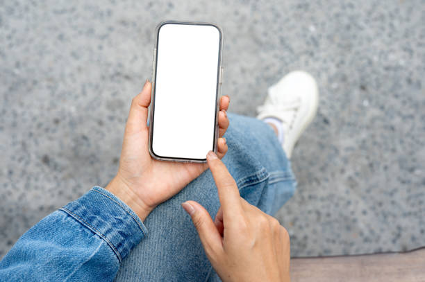 istock The hand in a denim jacket holding a smartphone and pointing at the screen. 2200747908
