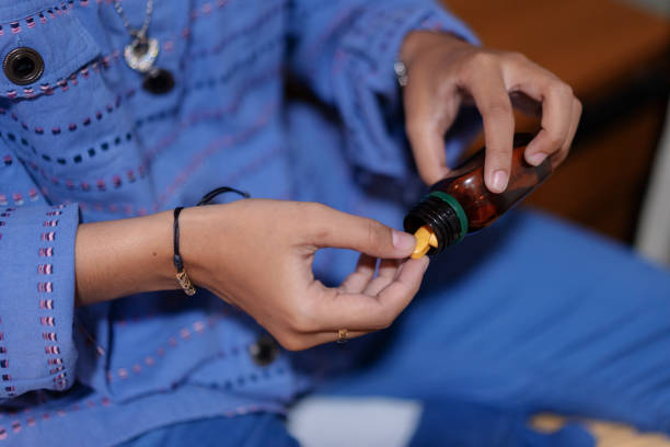 istock Close-Up of Hands Taking Medicine Pill from Container 2200749317