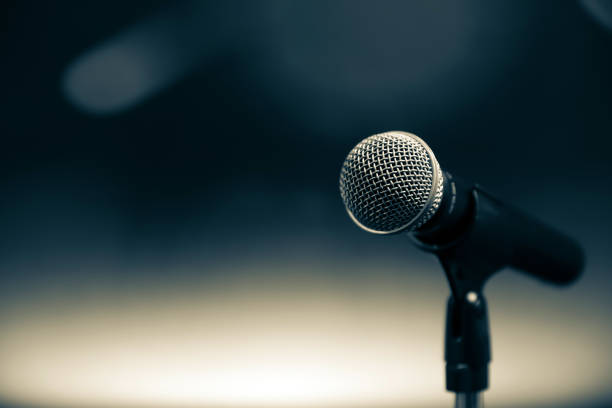 istock Public speaking backgrounds, Close-up the microphone on stand for speaker speech presentation stage performance with blur and bokeh light background. 2200755214