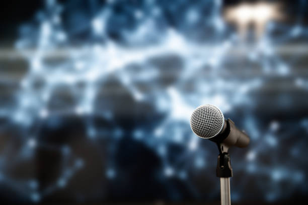 Public speaking backgrounds, Close-up the microphone on stand for speaker speech presentation stage performance with blur and bokeh light background.