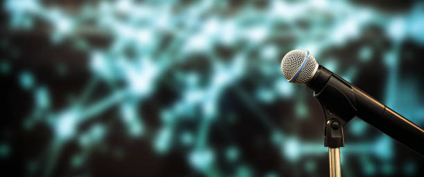 istock Public speaking backgrounds, Close-up the microphone on stand for speaker speech presentation stage performance with blur and bokeh light background. 2200755253