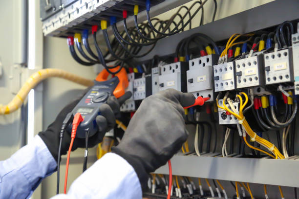 istock Close-up hand of electrical engineering using measuring equipment tool to checking electricity at circuit breaker and cable wiring system for maintenance in main power distribution board. 2200755357