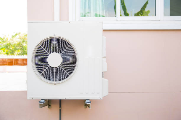 istock External split wall type of house air conditioner compressor unit installed on the outside of the building. 2200755390