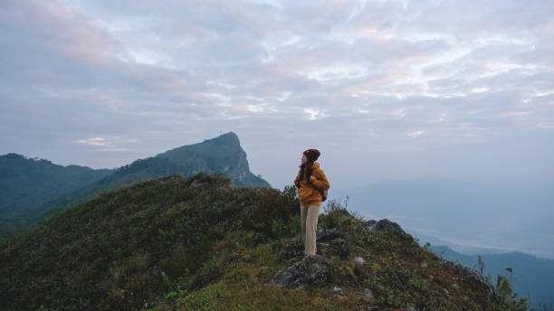 istock A woman standing on mountain peak on cloudy morning 2200759087
