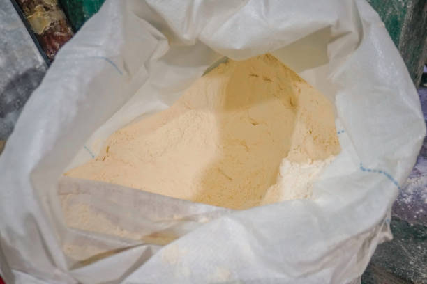 Stock photo shows bakery, a bag of flour sits alongside other raw ingredients, ready for baking. These essential staples are the foundation for creating delicious pastries and baked goods. The image captures the preparation process, showcasing the importance of quality ingredients in baking