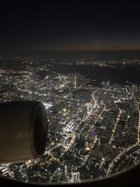 istock Sunset view from inside a plane with brightly lit city 2200761478