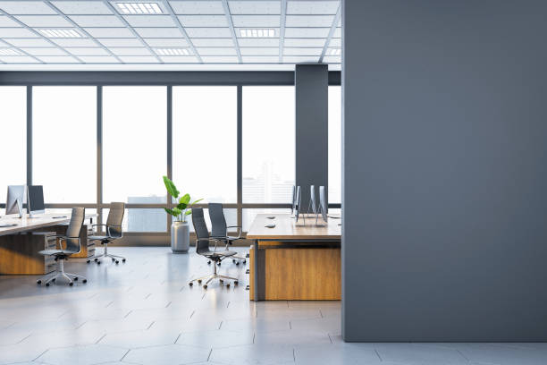 istock Modern spacious office interior with large windows and wooden desks. 3D Rendering 2200762048