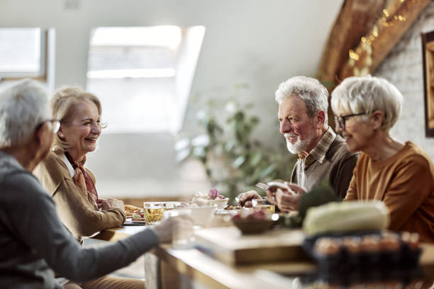 istock Happy senior couples talking during lunch in dining room. 2200771288