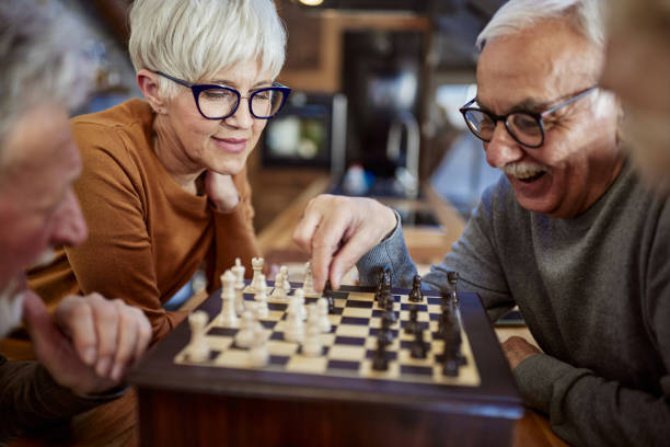 istock Happy senior friends playing chess at home. 2200771670