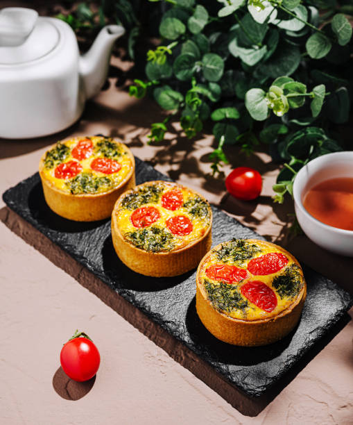 istock Delicious savory tarts with vegetables served on a slate platter 2200772206