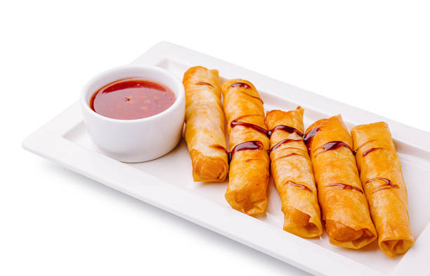 istock Delightful crispy spring rolls served with sweet and tangy dipping sauce on a white platter 2200774137
