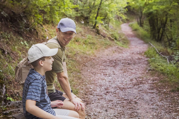 istock Connecting with nature. Father and son exploring forest.  Precious family moments while enjoying their adventure in parkland. 2200774532