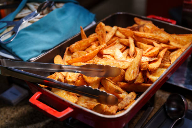 A tray of golden and crispy potato wedges served at a hotel buffet, offering a delicious and savory side dish option for guests.
