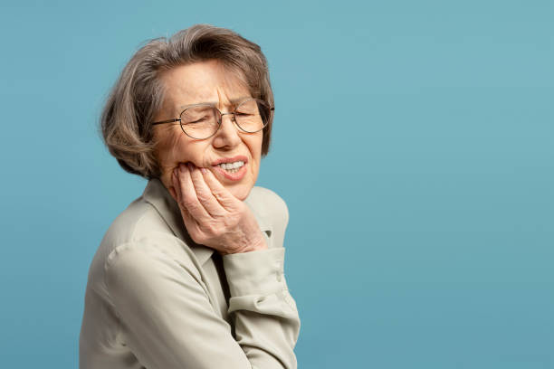istock Elderly Woman Experiencing Toothache on Blue Background 2200774650