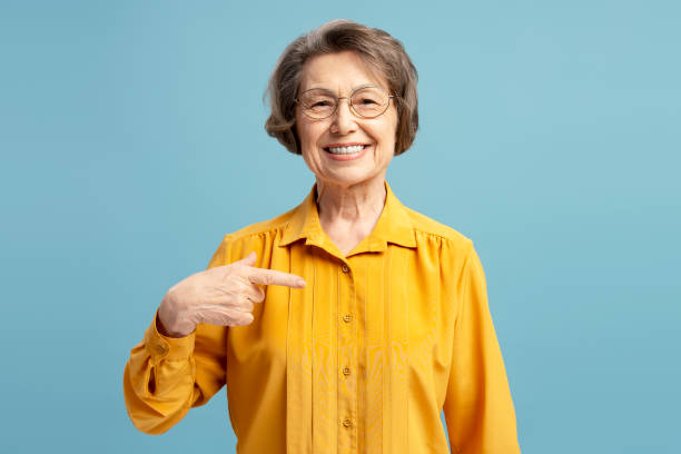 istock Elderly Woman Smiling and Pointing Cheerfully at Herself 2200774679