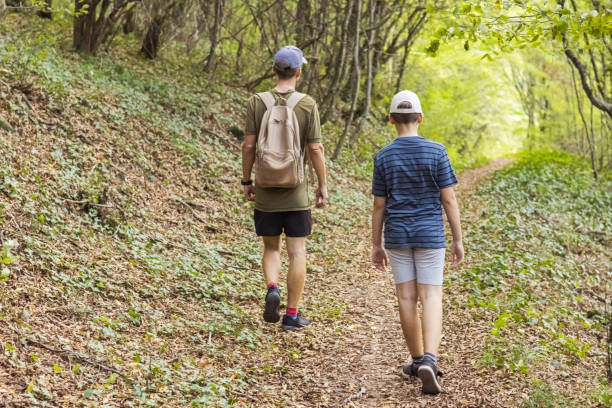 istock Connecting with nature. Father and son exploring forest.  Precious family moments while enjoying their adventure in parkland. 2200774717