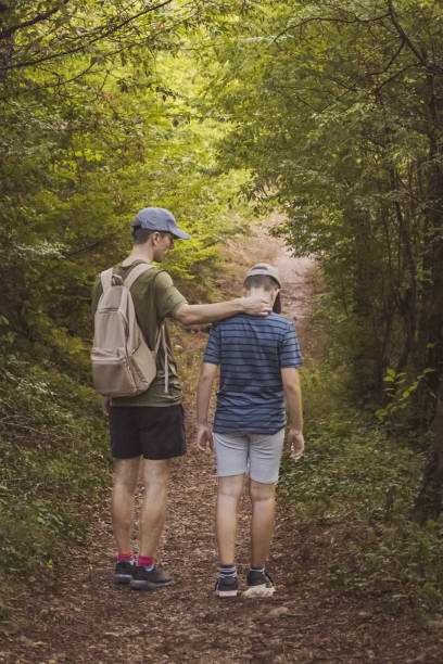 istock Connecting with nature. Father and son exploring forest.  Precious family moments while enjoying their adventure in parkland. 2200775672