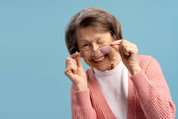 istock Playful senior woman winking and lowering her eyeglasses while smiling 2200775680