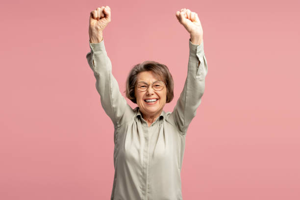 istock Elderly Woman Celebrating with Raised Arms 2200775738