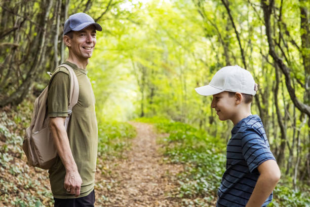 Connecting with nature. Father and son exploring forest.  Precious family moments while enjoying their adventure in parkland.