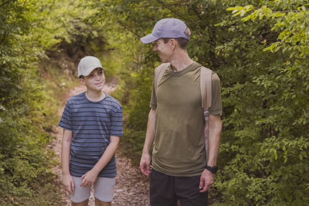 istock Connecting with nature. Father and son exploring forest.  Precious family moments while enjoying their adventure in parkland. 2200776495