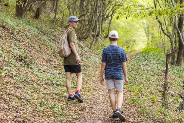 istock Connecting with nature. Father and son exploring forest.  Precious family moments while enjoying their adventure in parkland. 2200776635