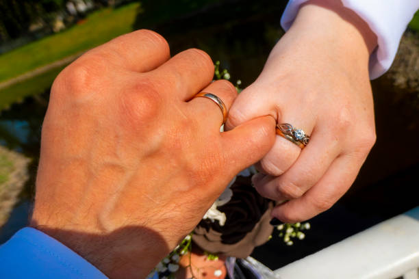 men holding woman hand with golden wedding ring with diamond. Wedding ring before the proposal. Luxury wedding rings. newlyweds holding hands showing rings