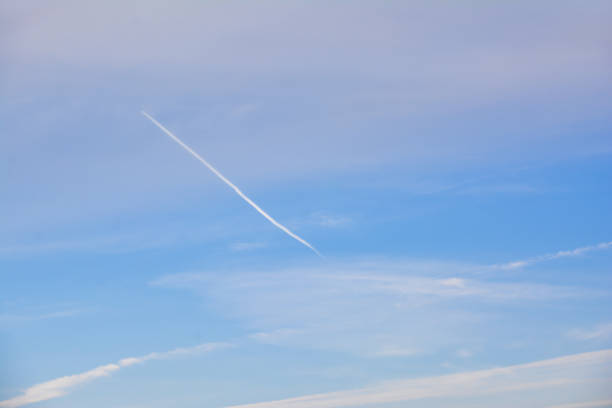 Blue sky with unique clouds. Plane trail on sky