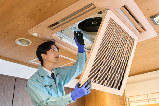 A man checking the air conditioning equipment in a restaurant stock photo